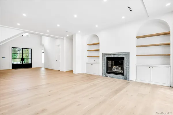 a view of an empty room with a fireplace and a window