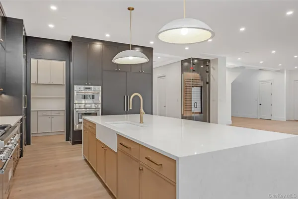 a large kitchen with stainless steel appliances a large counter top a refrigerator and a sink