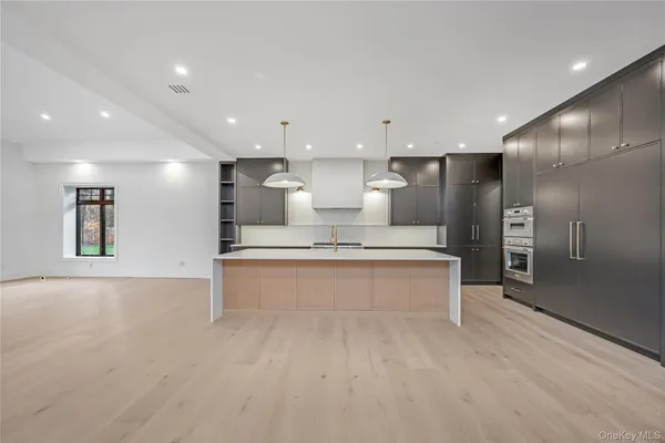 a large white kitchen with a large counter top appliances and cabinets