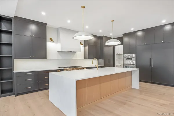 a kitchen with kitchen island a counter top a sink stainless steel appliances and cabinets