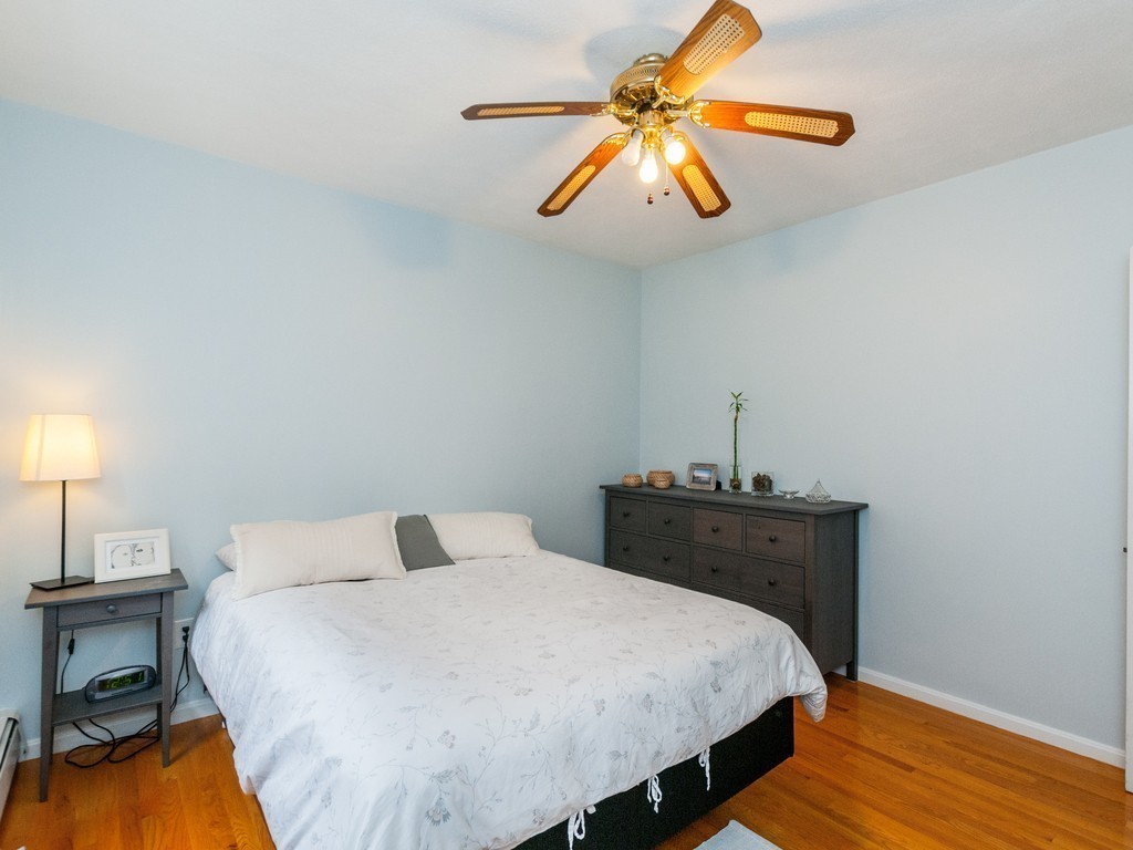 12 Regent Street Cambridge, MA 02140 - Photo 11 of 18 a bedroom with a bed and a chandelier