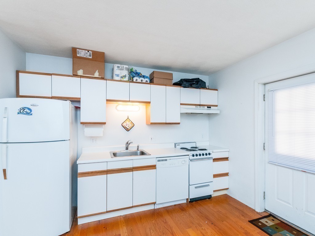 12 Regent Street Cambridge, MA 02140 - Photo 17 of 18 a kitchen with a refrigerator and white cabinets