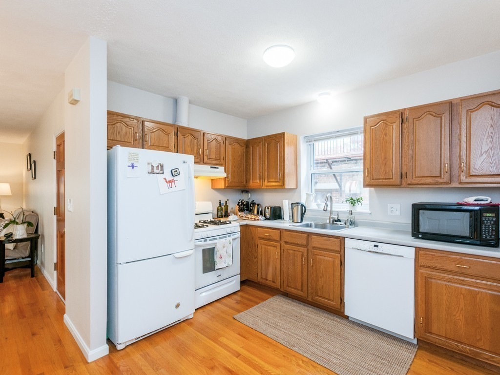 12 Regent Street Cambridge, MA 02140 - Photo 8 of 18 a kitchen with granite countertop cabinets stainless steel appliances a sink and a window