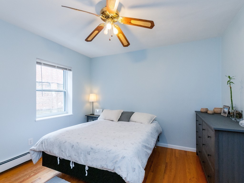 12 Regent Street Cambridge, MA 02140 - Photo 10 of 18 a bedroom with a bed and a chandelier