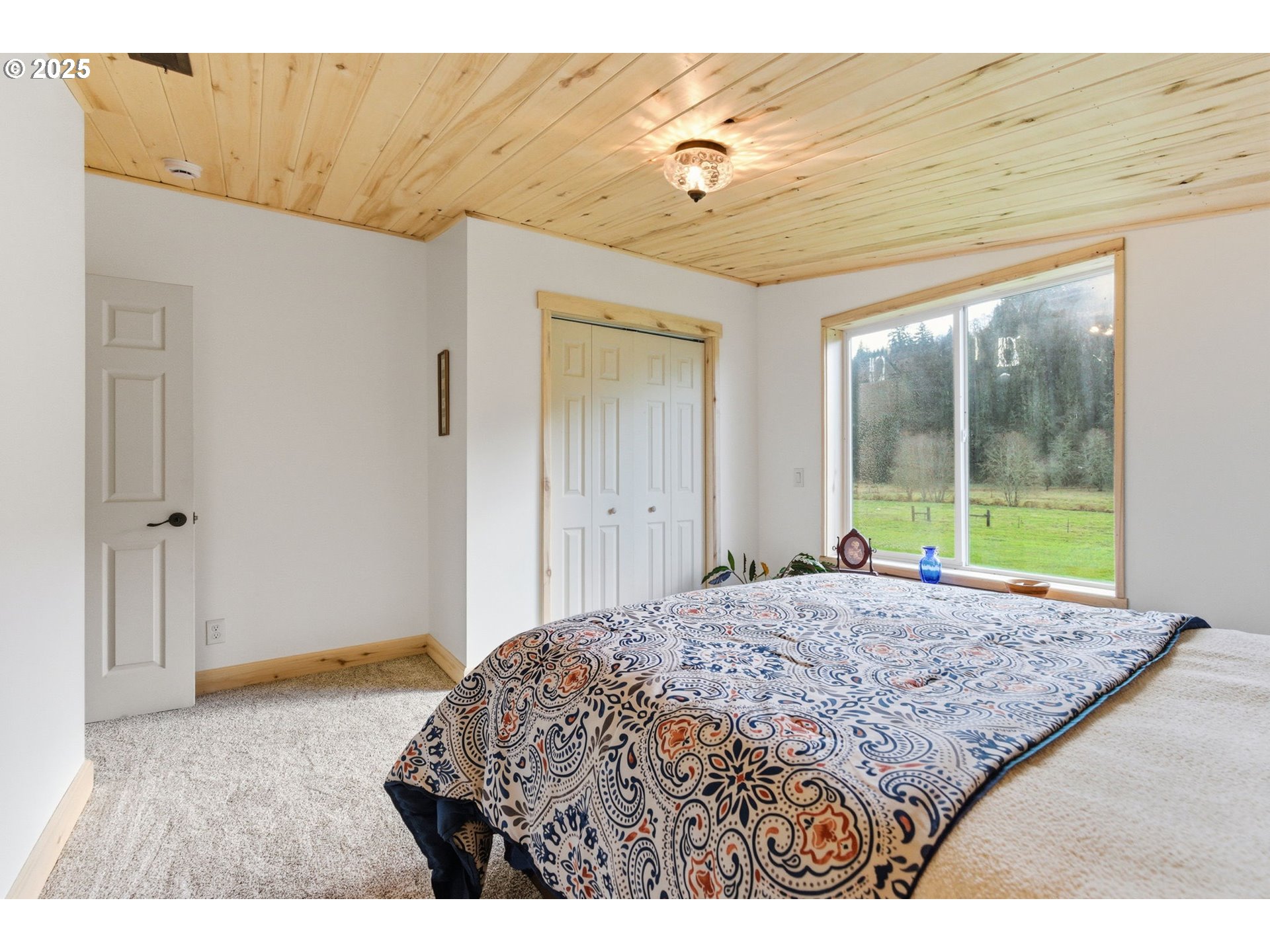 314 East Valley Road Skamokawa, WA 98647 - Photo 24 of 46 a bedroom with a bed and a large window