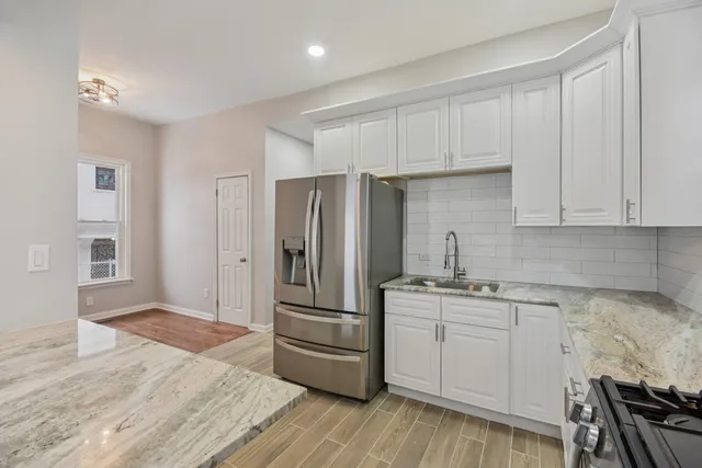 a kitchen with a refrigerator sink and cabinets