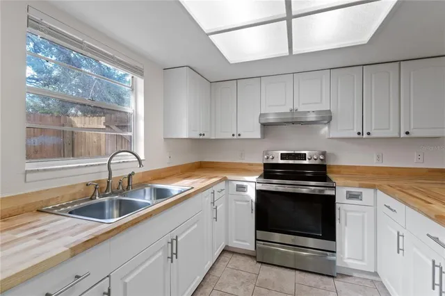 a kitchen with granite countertop a sink stainless steel appliances and cabinets