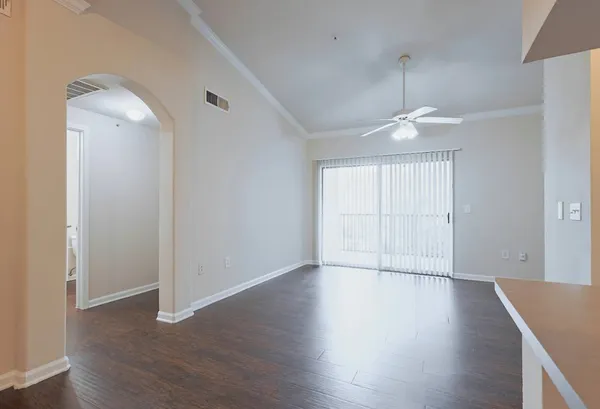 an empty room with wooden floor mirror and windows