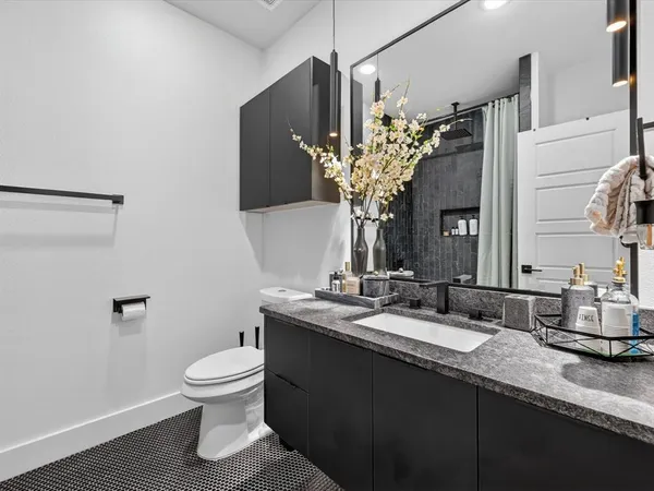 a bathroom with a granite countertop sink a toilet and a mirror