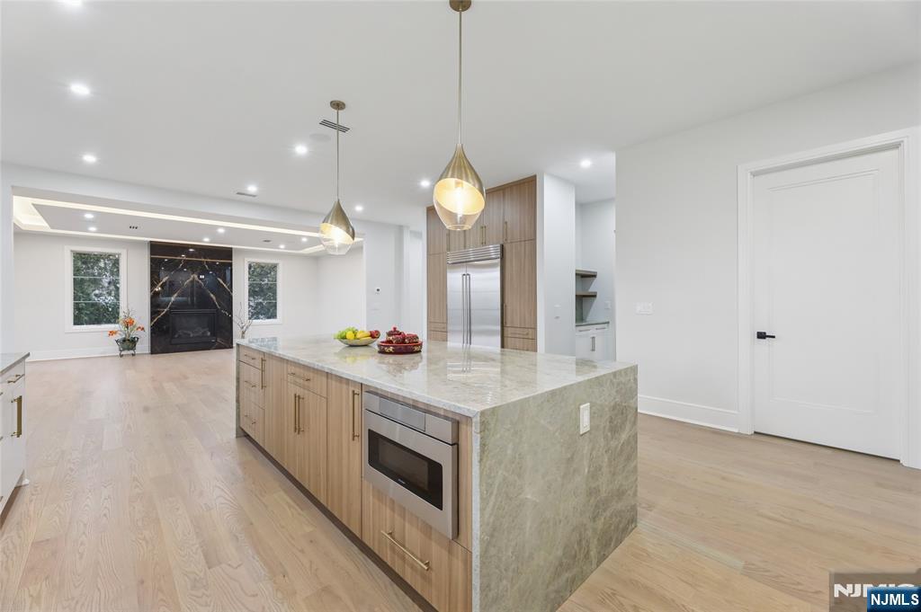 311 North Farview Avenue Paramus, NJ 07652 - Photo 8 of 50 a large white kitchen with a large island oven a stove a sink a dining table and chairs