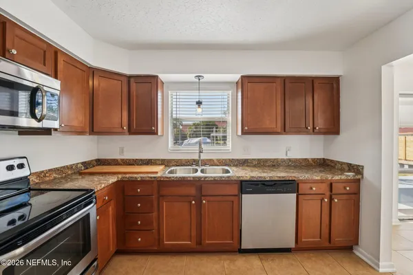 a kitchen with stainless steel appliances granite countertop a sink stove and microwave
