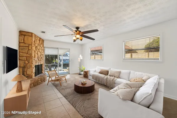 a living room with furniture ceiling fan and a flat screen tv