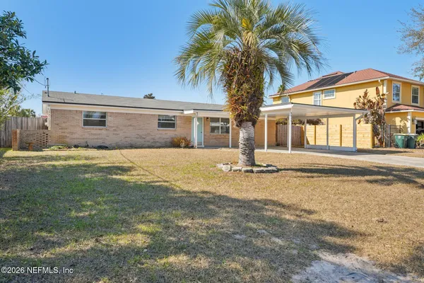 a front view of house with yard and trees around