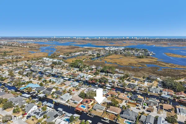 an aerial view of ocean and residential houses with outdoor space