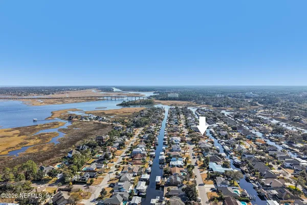 an aerial view of ocean and residential houses with outdoor space