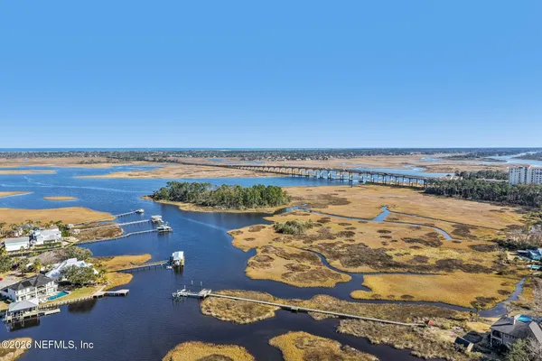 an aerial view of ocean and residential houses with outdoor space