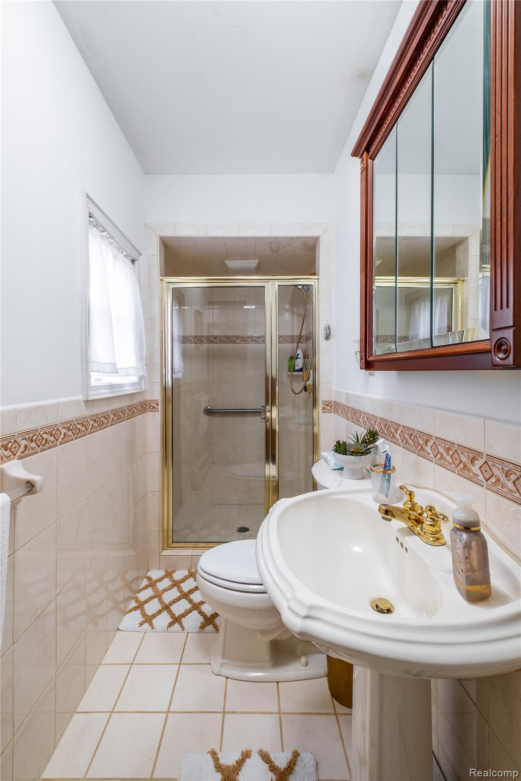12164 Miller Road Lennon, MI 48449 - Photo 23 of 35 Full bathroom featuring tile walls, a wainscoted wall, a shower stall, and light tile patterned floors