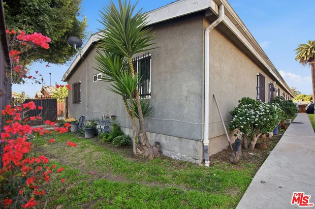 a backyard of a house with flower plants