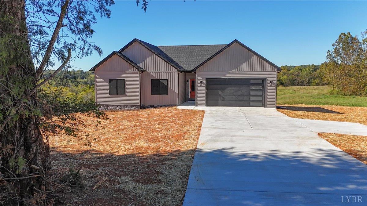 a front view of house with yard and trees in the background