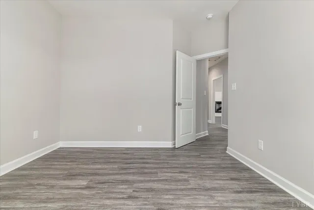 a view of an empty room with wooden floor and closet