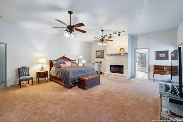 a bedroom with a bed a fireplace and a chair