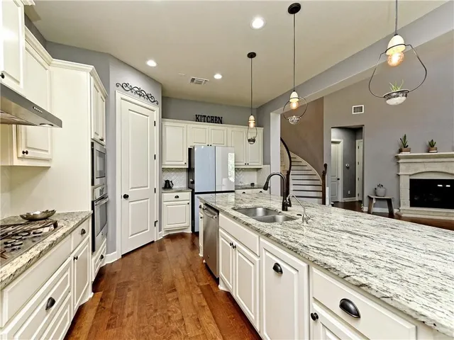 a large kitchen with stainless steel appliances granite countertop a stove and a sink