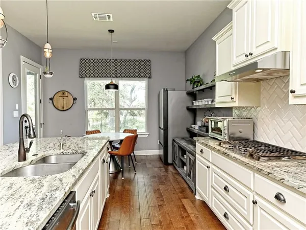 a kitchen with stainless steel appliances granite countertop a sink stove and refrigerator