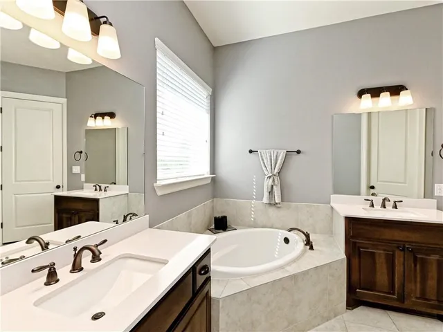 a bathroom with a tub sink and mirror