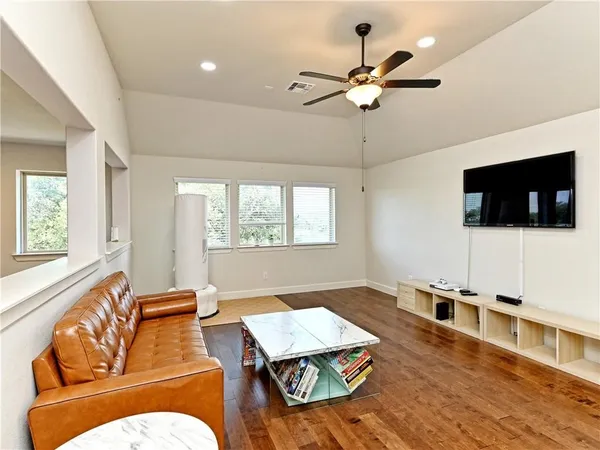 a living room with furniture flat screen tv and a window