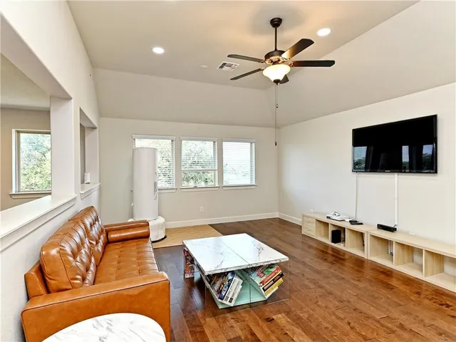a living room with furniture flat screen tv and a window