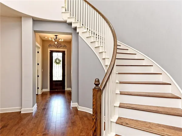 a view of staircase with wooden floor and white walls