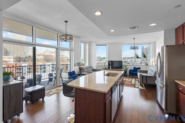 a kitchen with counter top space a sink appliances and living room view