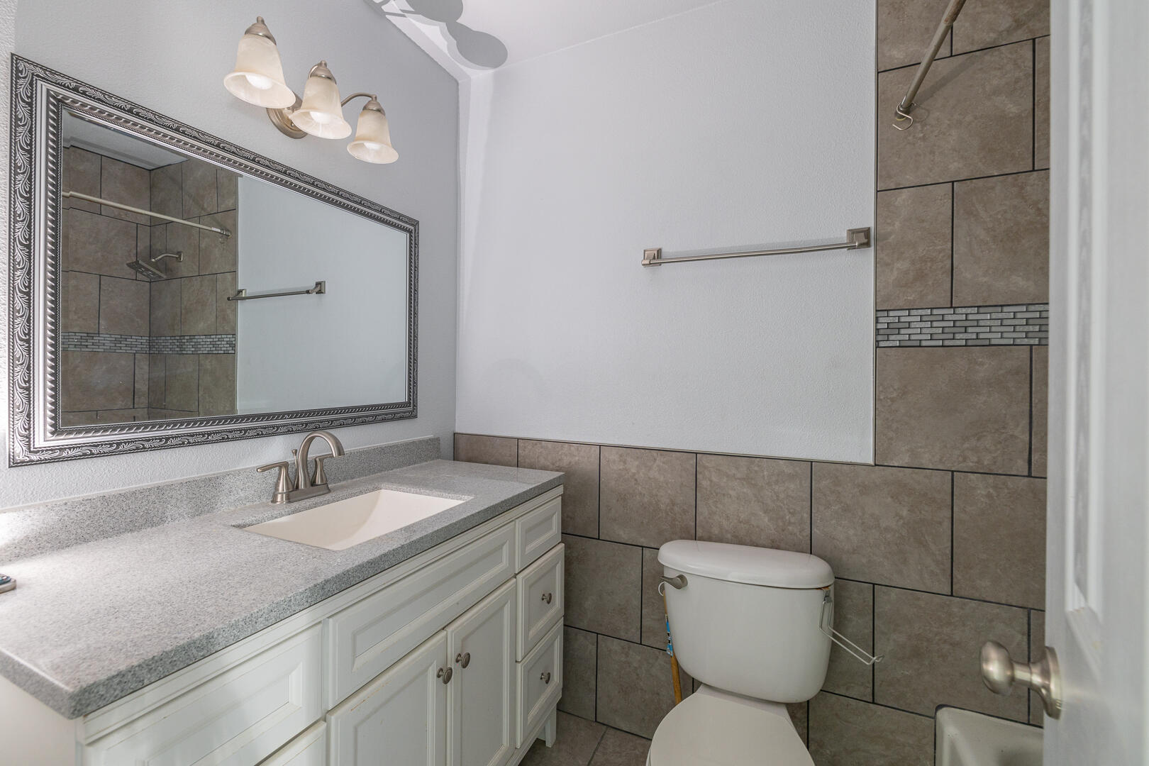 5403 13th Street Lubbock, TX 79416 - Photo 16 of 28 a bathroom with a toilet sink and mirror