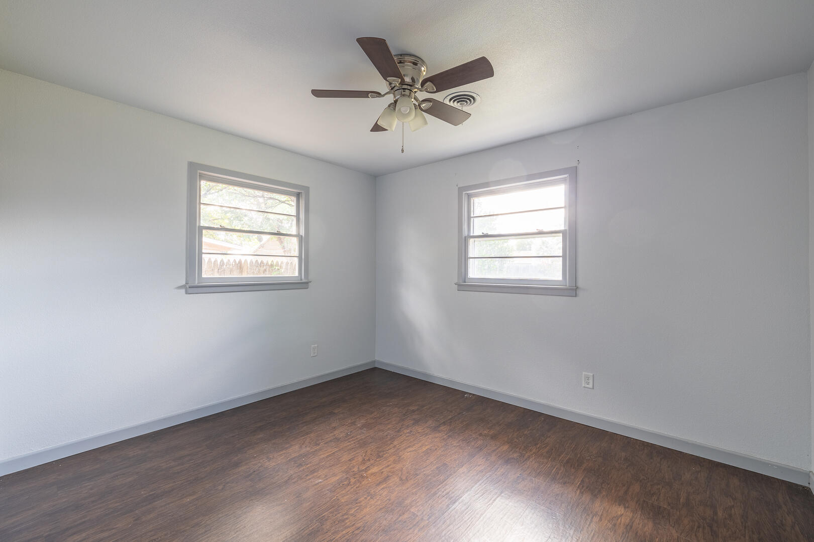 5403 13th Street Lubbock, TX 79416 - Photo 18 of 28 an empty room with wooden floor and windows