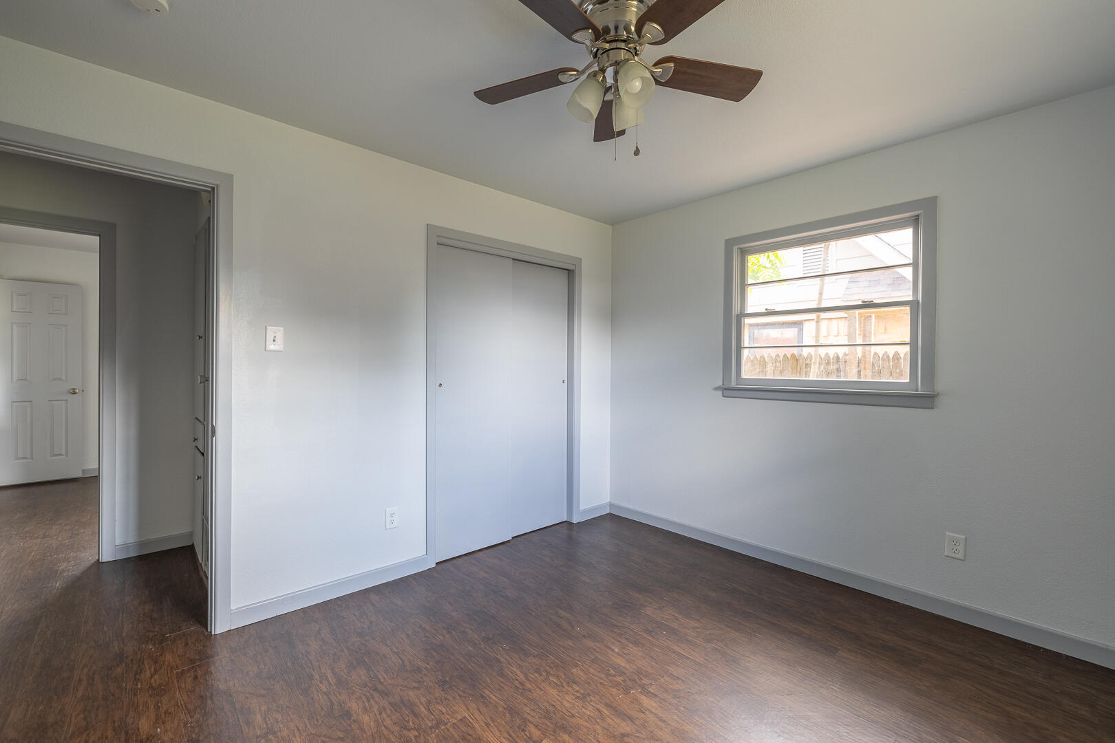 5403 13th Street Lubbock, TX 79416 - Photo 19 of 28 an empty room with wooden floor chandelier fan and windows