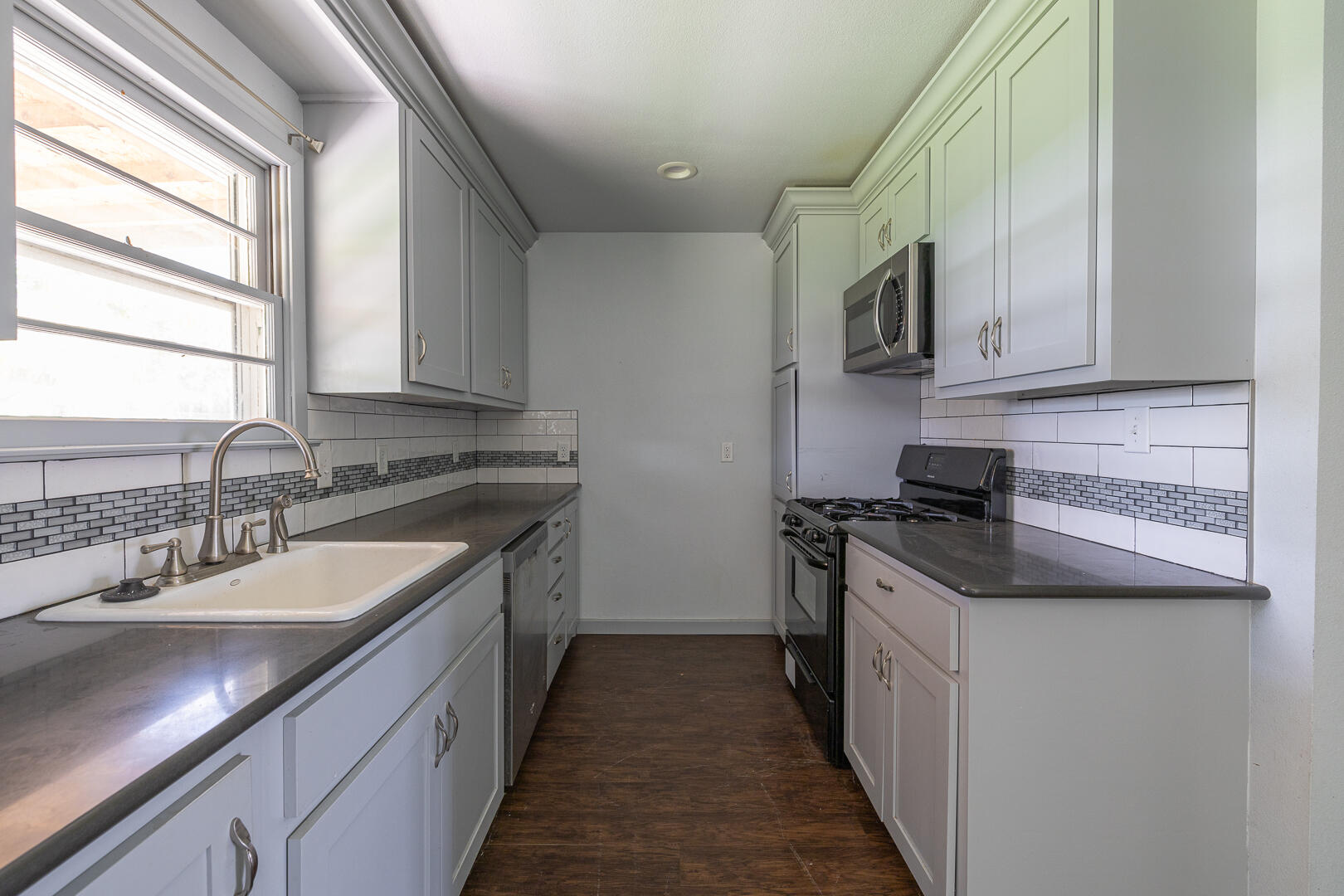 5403 13th Street Lubbock, TX 79416 - Photo 6 of 28 a kitchen with stainless steel appliances granite countertop a sink stove and refrigerator