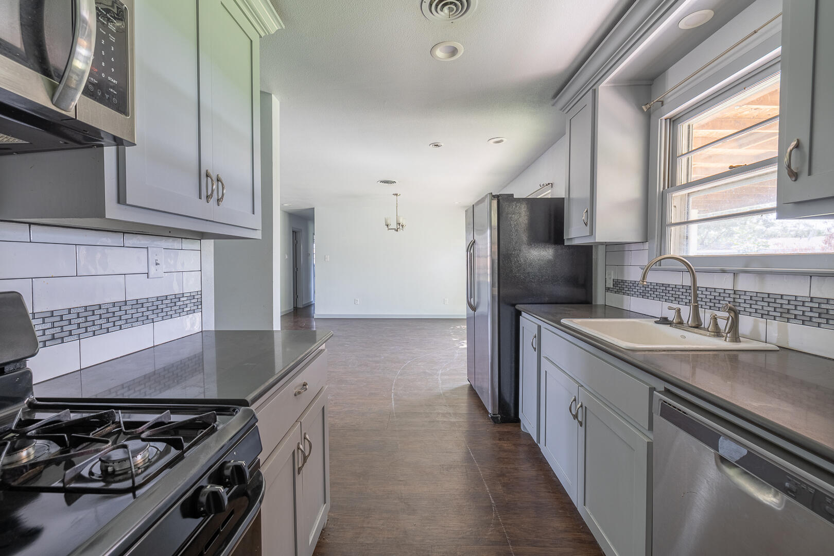 5403 13th Street Lubbock, TX 79416 - Photo 10 of 28 a kitchen with stainless steel appliances granite countertop a sink stove refrigerator and cabinets