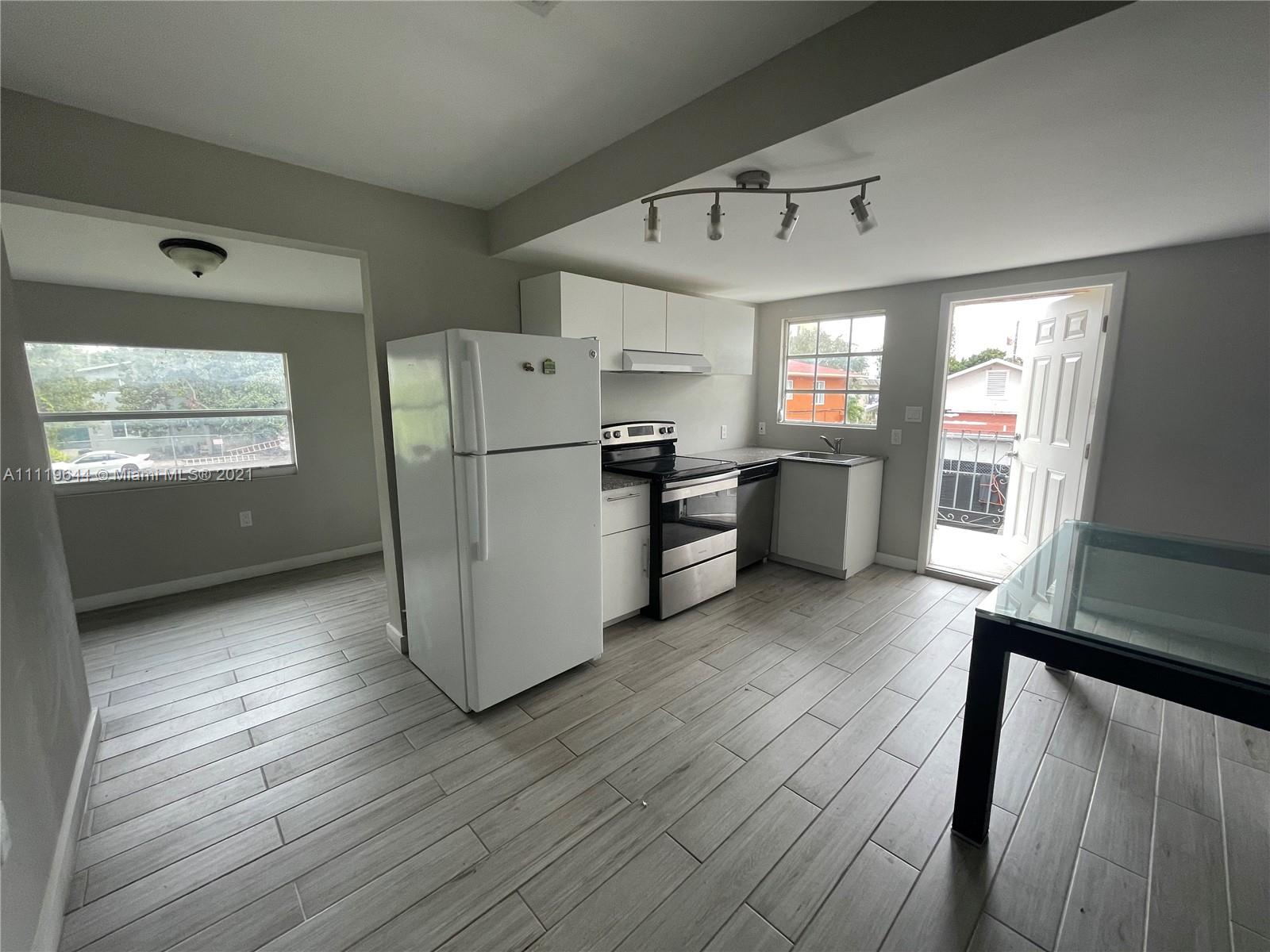 1035 Northwest 5th Street, Unit 3 Miami, FL 33128 - Photo 1 of 6 a kitchen with a refrigerator and wooden floor
