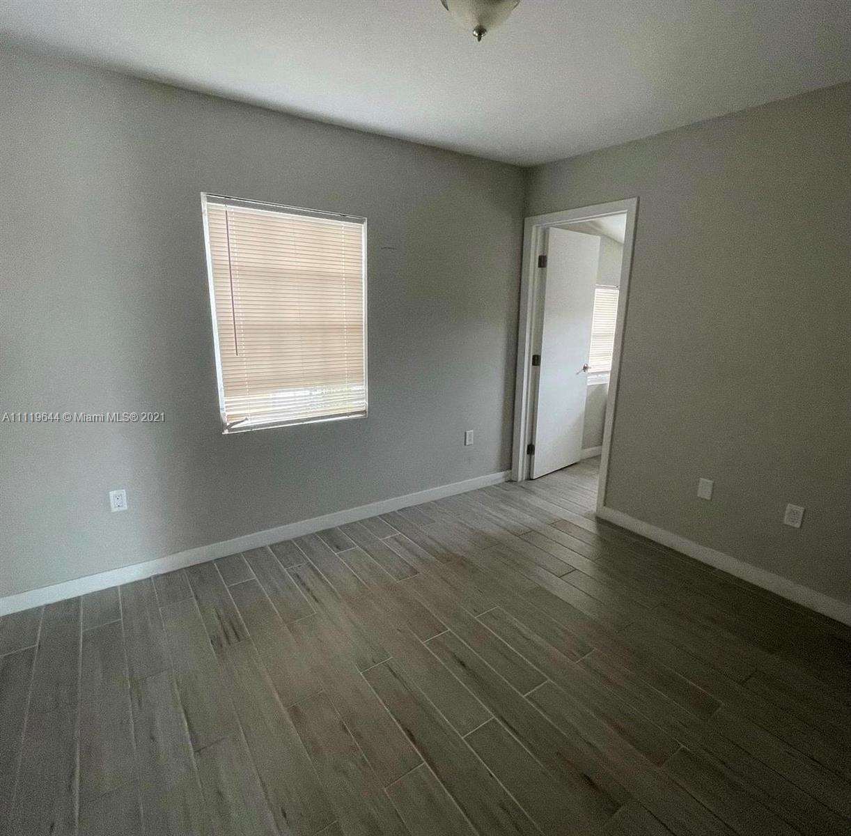 1035 Northwest 5th Street, Unit 3 Miami, FL 33128 - Photo 4 of 6 an empty room with wooden floor and windows