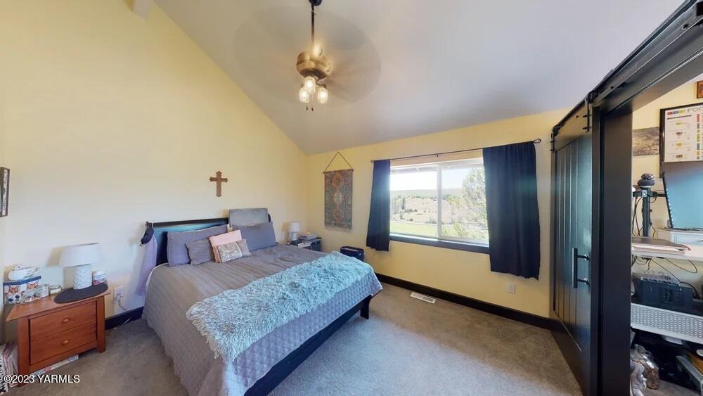 14751 Cottonwood Canyon Road Yakima, WA 98908 - Photo 23 of 53 a bedroom with a large bed and a chandelier next to a window