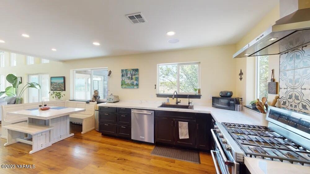 14751 Cottonwood Canyon Road Yakima, WA 98908 - Photo 10 of 53 a large kitchen with stainless steel appliances a stove a sink dishwasher and cabinets with wooden floor