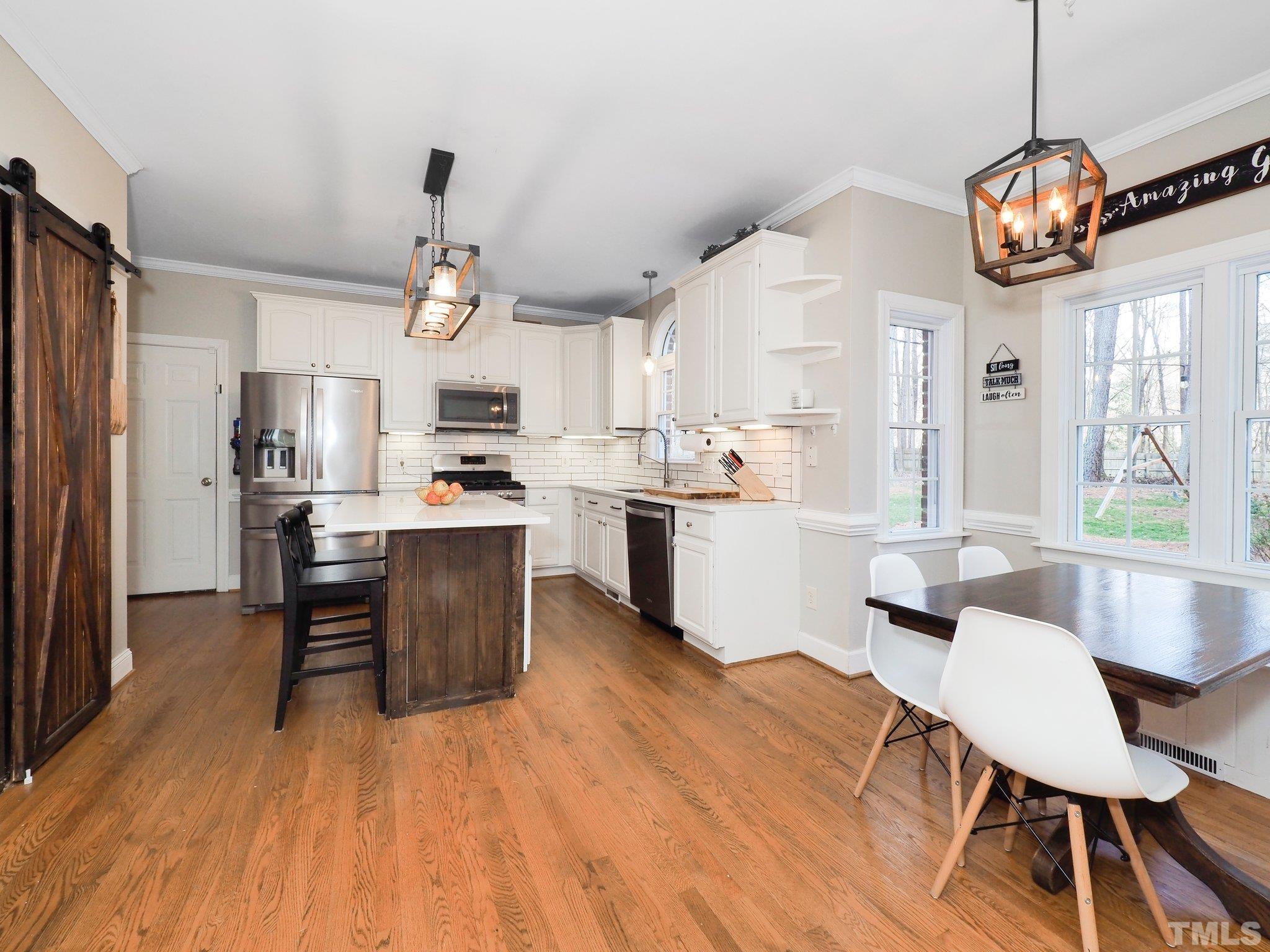 4412 Black Lion Way Raleigh, NC 27610 - Photo 13 of 32 a view of a dining room and livingroom with furniture wooden floor a chandelier