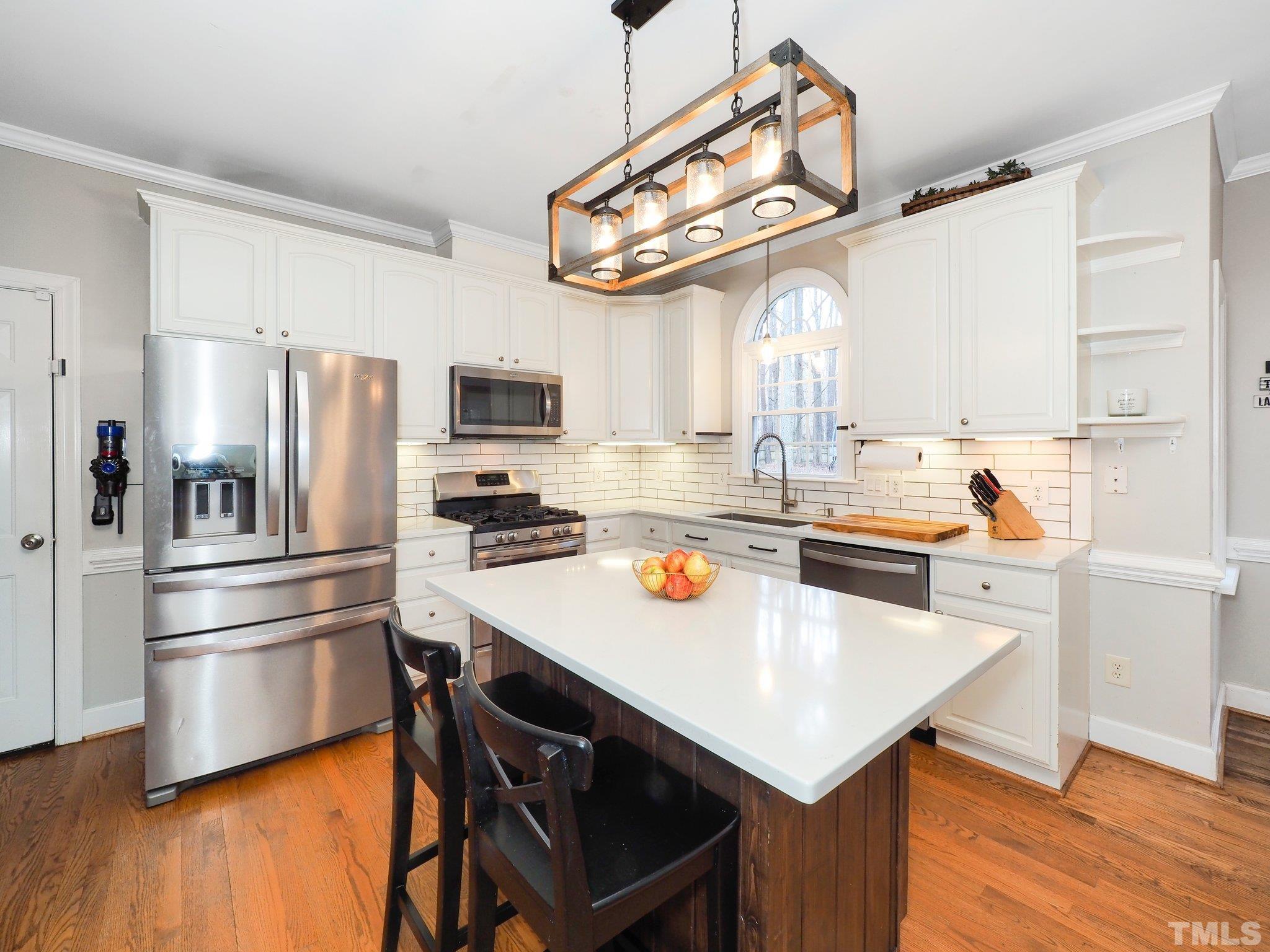4412 Black Lion Way Raleigh, NC 27610 - Photo 15 of 32 a kitchen with a refrigerator a sink dishwasher and a stove with wooden floor