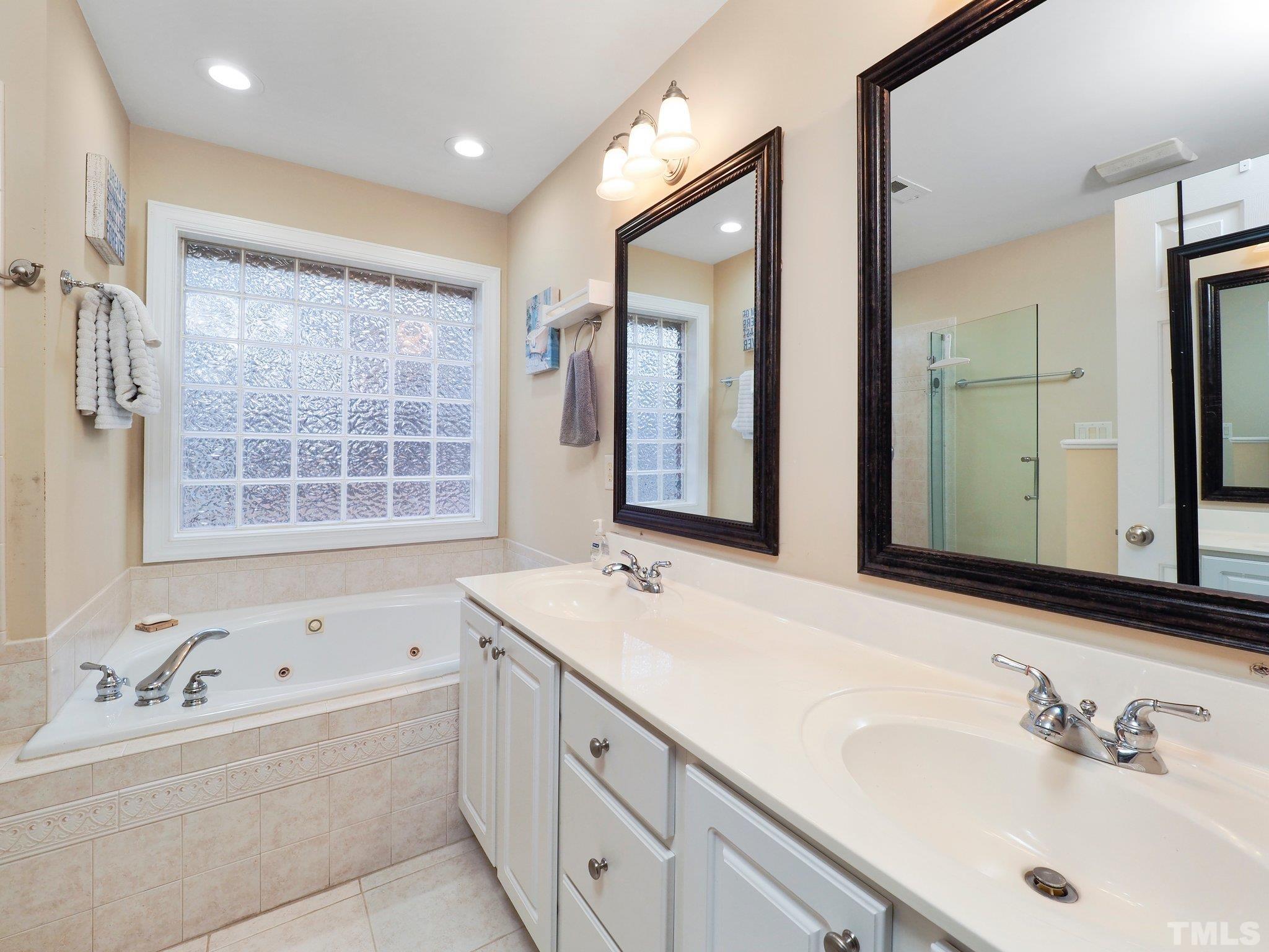 4412 Black Lion Way Raleigh, NC 27610 - Photo 21 of 32 a bathroom with a tub sink and mirror