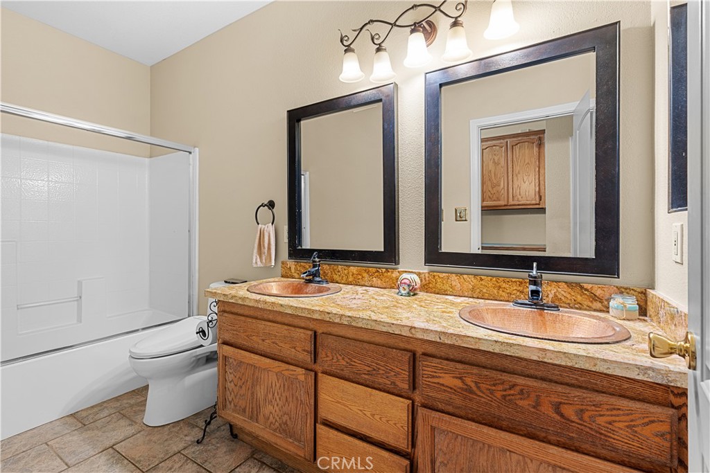 17492 Mariposa Avenue Riverside, CA 92504 - Photo 24 of 43 a bathroom with a double vanity sink toilet and mirror