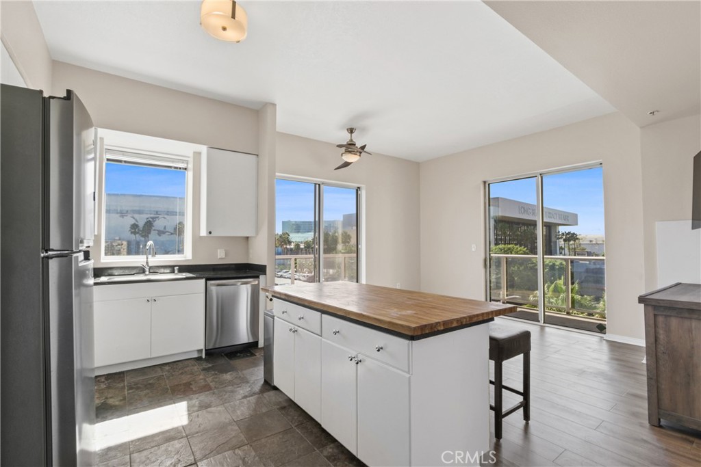 a kitchen with granite countertop a sink stainless steel appliances and window