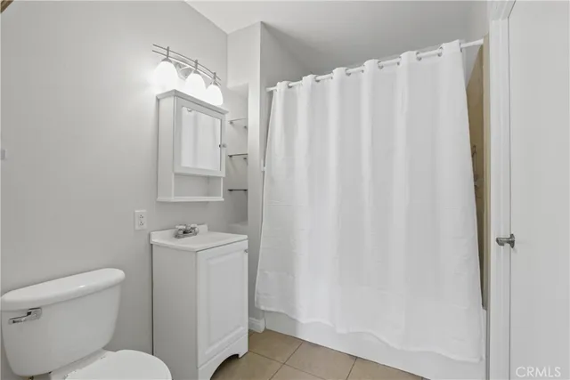 a bathroom with a toilet a sink and curtain