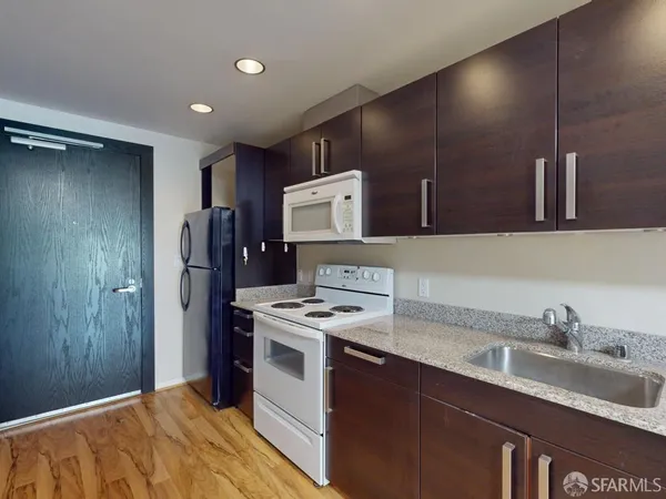 a kitchen with stainless steel appliances granite countertop a sink stove and refrigerator