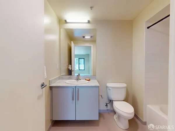 a bathroom with a toilet a sink and mirror
