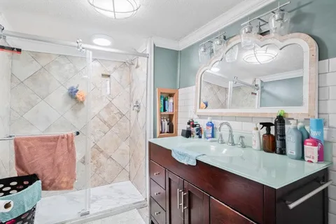 a bathroom with a sink mirror and a shower